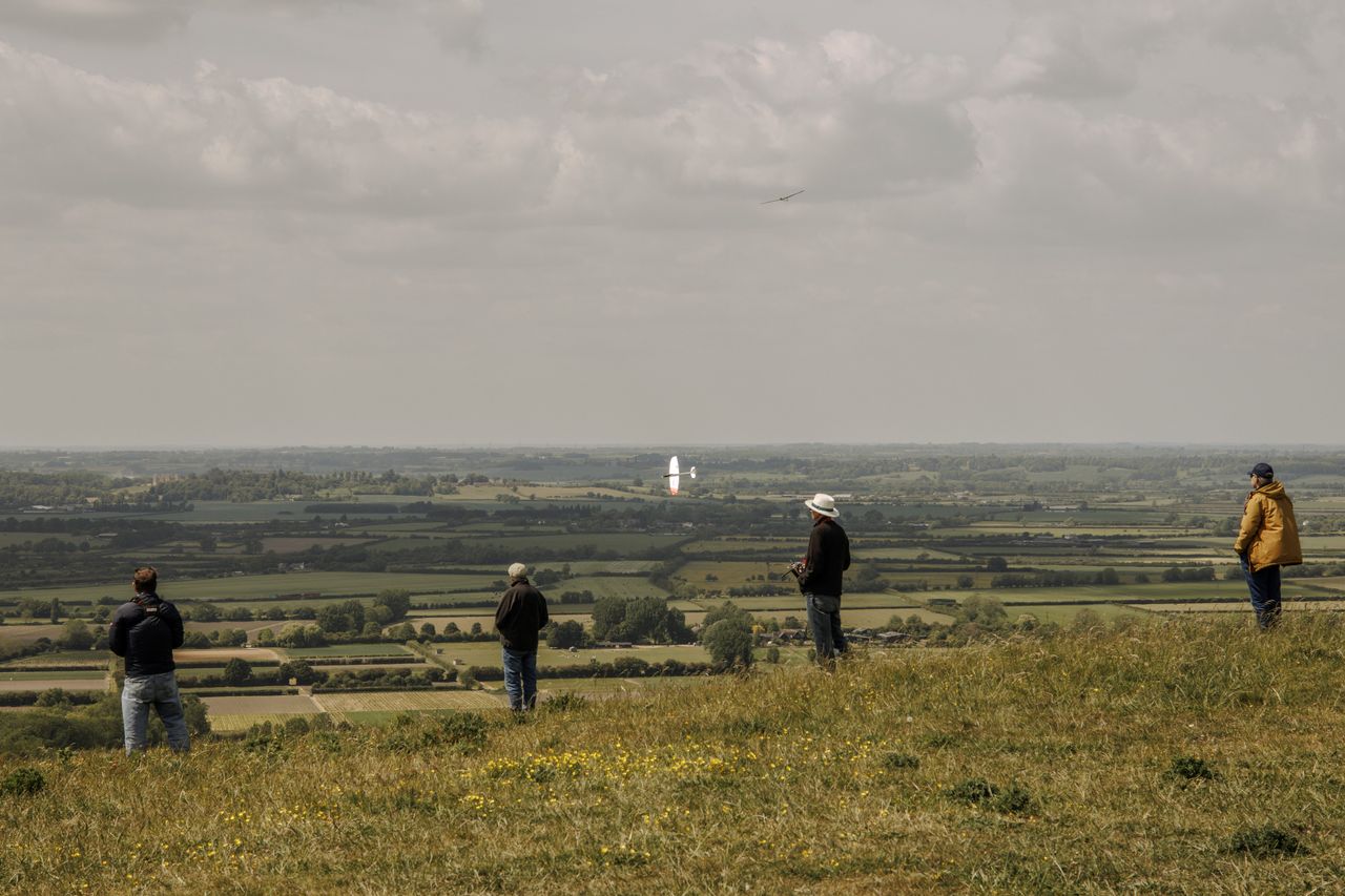 A group of hobbyists flying radio-controlled model aircraft gliders.